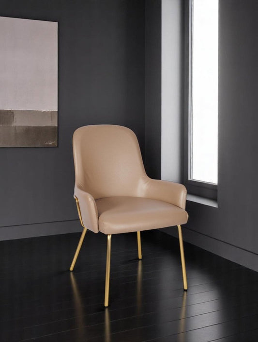 alt="Chic cream leather armchair with luxurious gold metal base for a modern look"