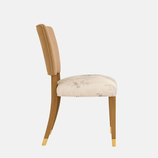 Upholstered dining chair with a cream fabric backrest and olive-green cushioned seat, featuring tapered wooden legs with brass-capped feet, shown on a white background
