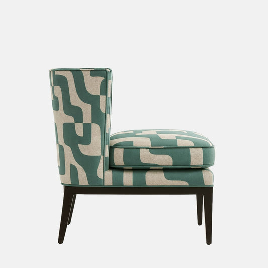 Side view of an armless lounge chair upholstered in teal and cream geometric fabric, with a tall straight back, thick seat cushion, and black tapered legs on a white background.