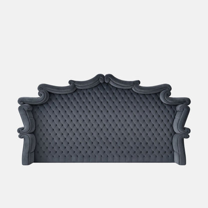 Upholstered blue tufted headboard with an ornate arched silhouette and rolled edges, featuring classic button detailing on a neutral background.