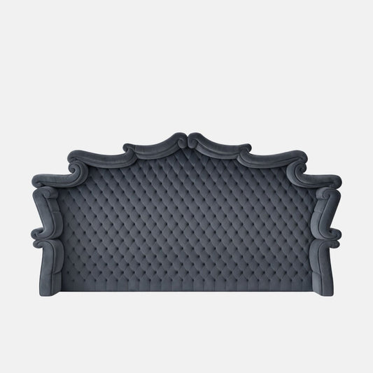 Upholstered blue tufted headboard with an ornate arched silhouette and rolled edges, featuring classic button detailing on a neutral background.