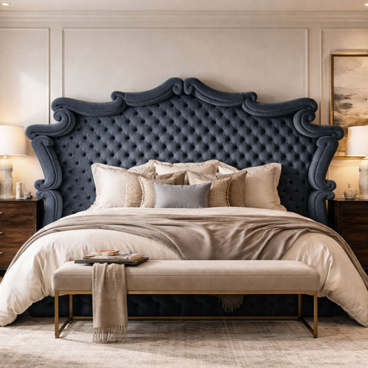 Luxurious bedroom with a large tufted blue headboard, neutral bedding, and an upholstered bench, styled with bedside tables and soft lighting.