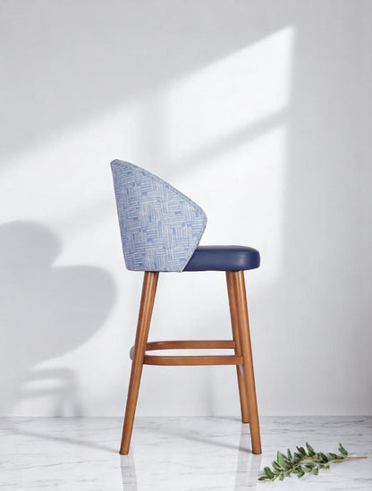 alt="Elegant blue kitchen stool with fabric back design, leather upholstered seat, and medium oak wood base"