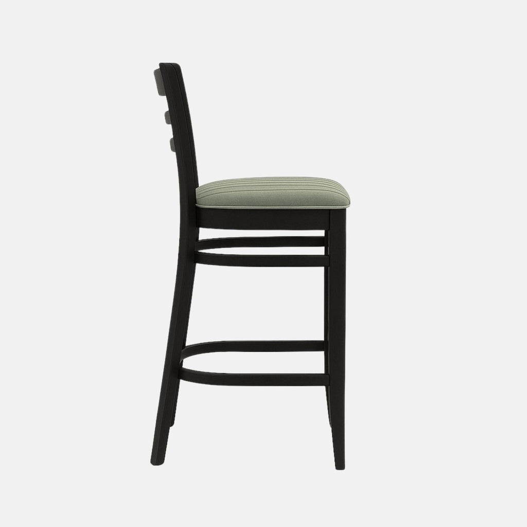 Modern wooden bar stool with black ladder-back design, cushioned seat upholstered in light green fabric, and sturdy black frame with footrest