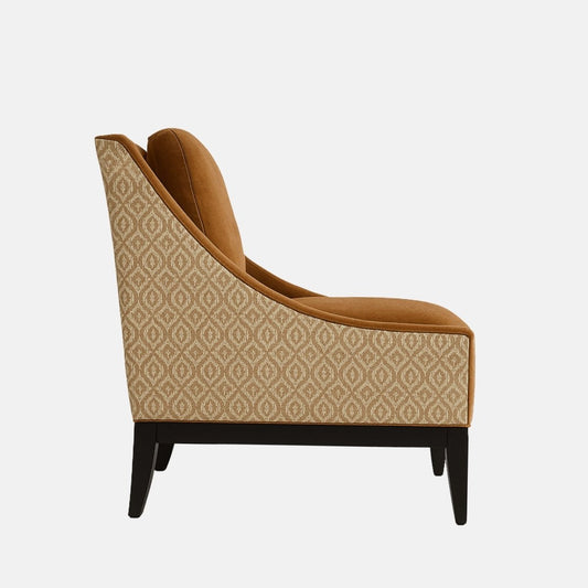 Contemporary accent chair with burnt orange velvet upholstery, matching button-tufted back cushion, patterned fabric on the sides, and black wooden legs.