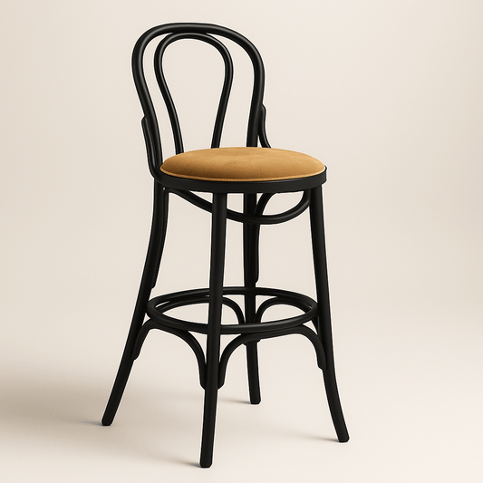 A classic bentwood barstool with a matte black frame and a round tan velvet seat cushion, featuring an elegantly curved double-loop backrest, rounded legs with supportive crossbars, and a smooth, minimalist design, set against a neutral off-white background.