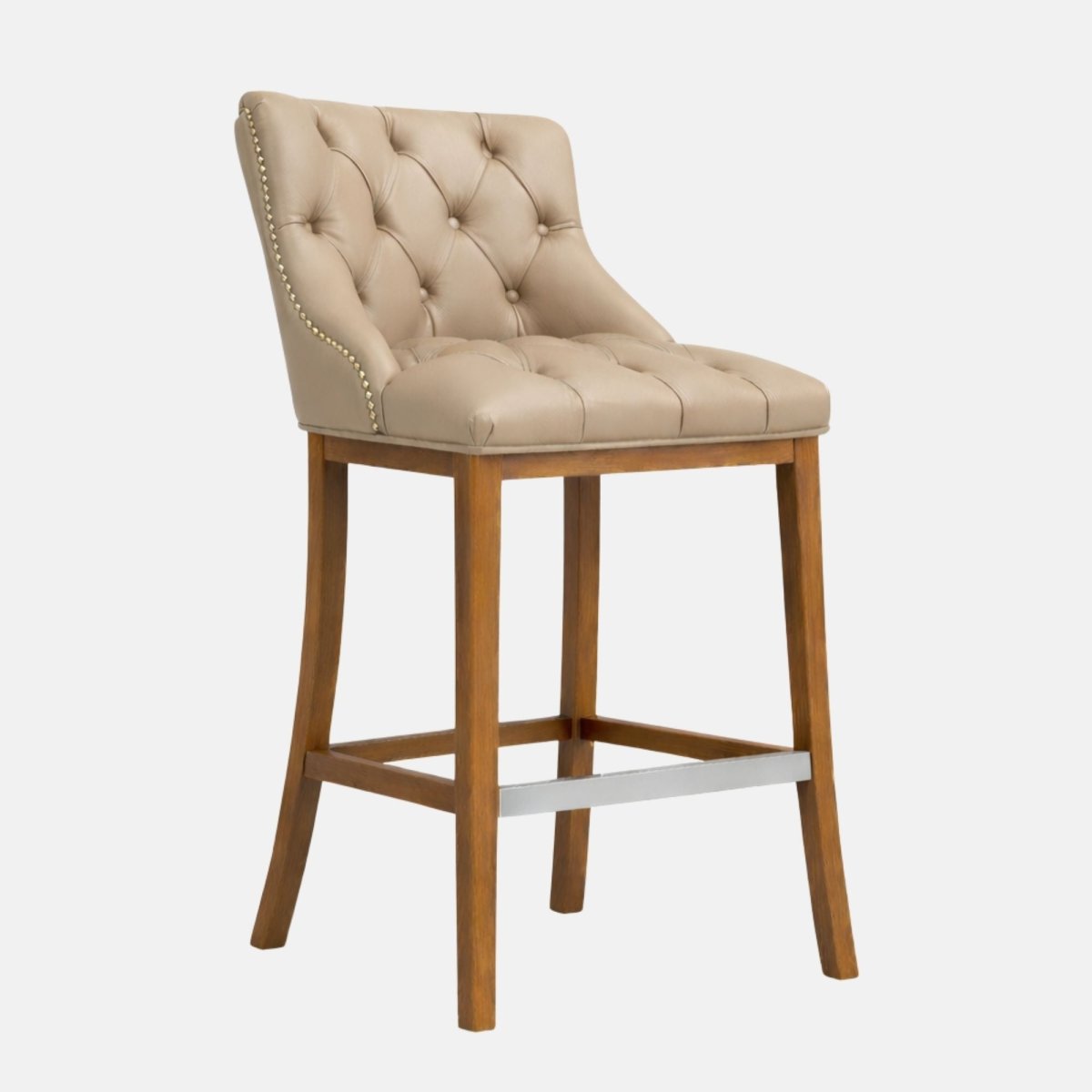 Beige button-tufted upholstered bar stool with nailhead trim, tapered wooden legs, and a metal footrest bar.