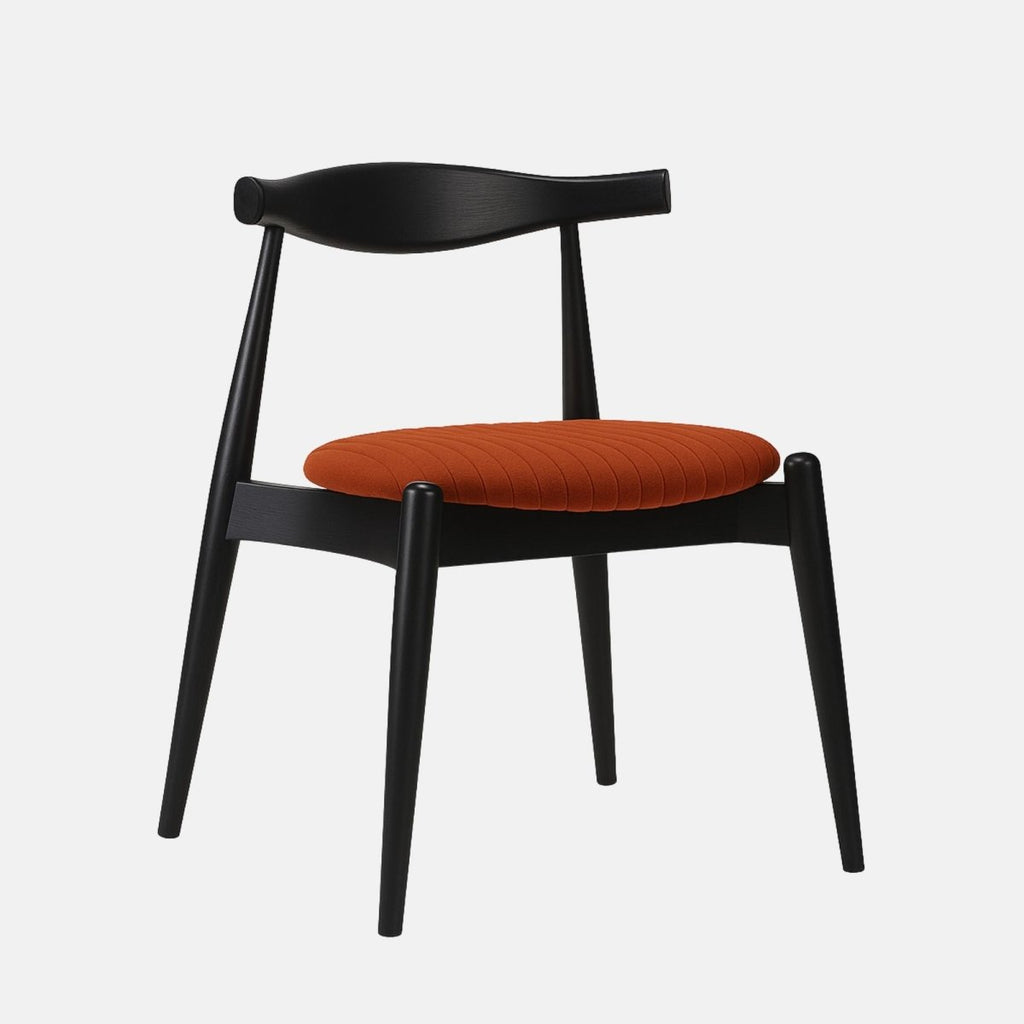 Modern dining chair with a black wooden frame and sculpted backrest, featuring a round burnt orange upholstered seat with vertical stitching, set against a light grey background