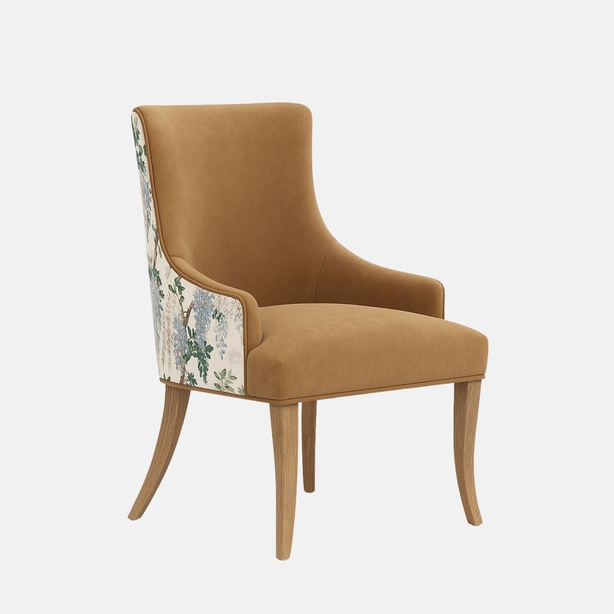 Upholstered dining chair in warm tan fabric with gently curved arms and cushioned seat, featuring a floral-patterned fabric panel on the outer back and natural wooden legs, shown on a white background