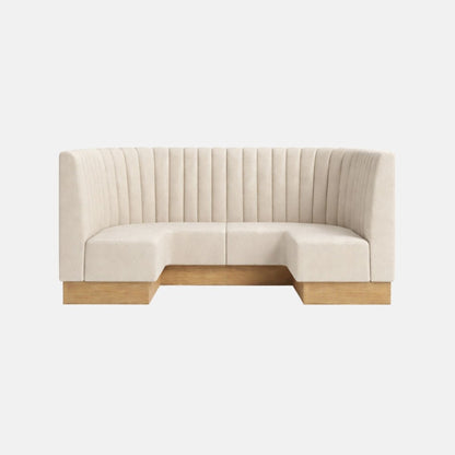 Curved banquette seating upholstered in cream fabric with vertical fluted detailing and a wooden plinth base, designed for stylish booth or restaurant interiors.