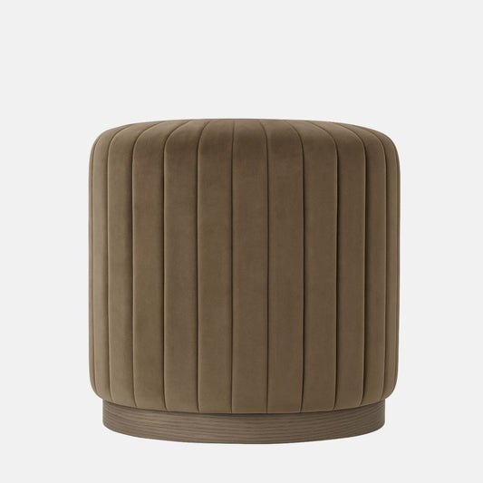 Taupe velvet round ottoman with vertical channel upholstery and natural wood base modern upholstered stool or side table for living room, bedroom, or hotel lounge.