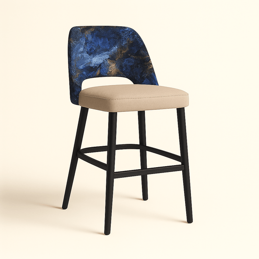 A modern barstool with a beige cushioned seat, matte black wooden legs, and a curved backrest upholstered in a textured abstract fabric featuring deep blue, black, and gold tones, shown from a side view against a soft beige background.