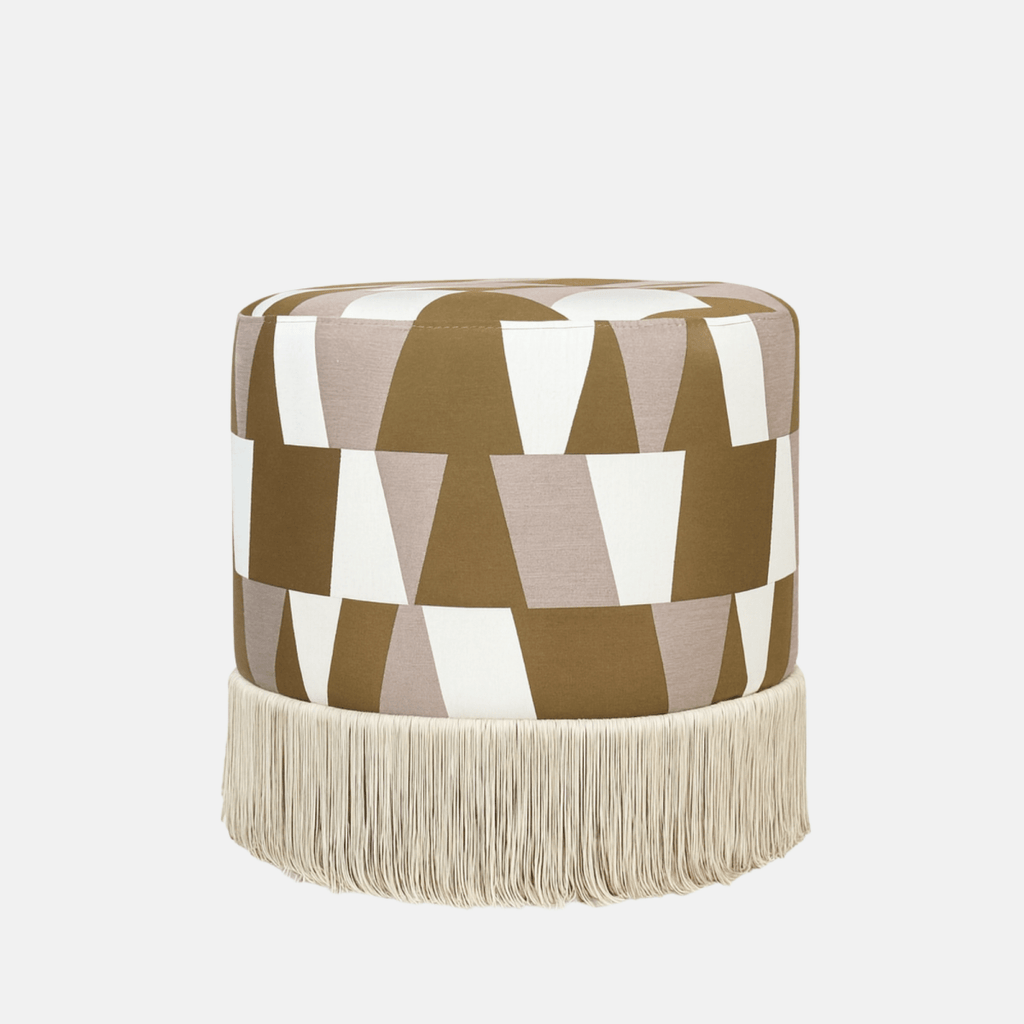 Geométrico Pouffe with bold geometric fabric upholstery and fringe base – handmade cylindrical pouffe, versatile as seat, footrest, or accent piece.