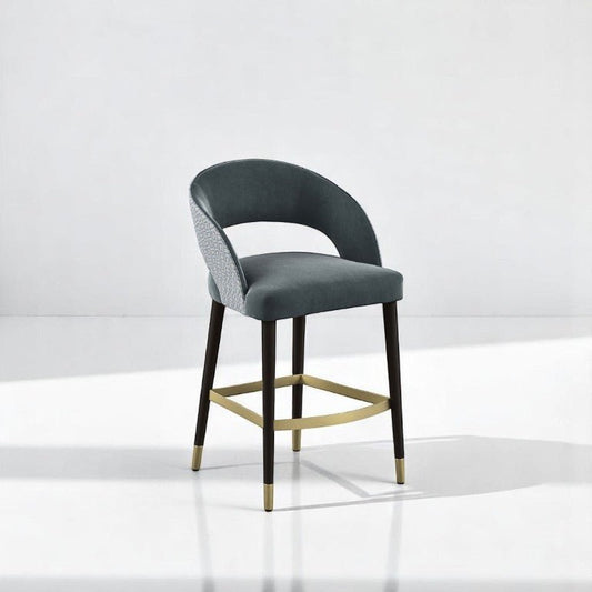 alt="Sleek and modern bar stool with soft seating and a polished gold leg rest for added flair"