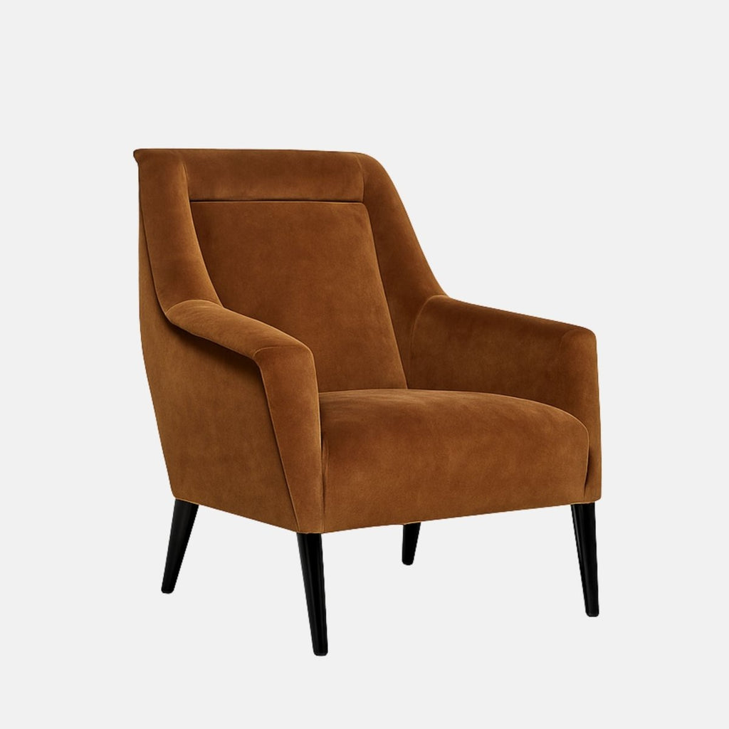 Mid-century style armchair with warm brown velvet upholstery, angled arms, a smooth backrest, and slim black tapered legs.