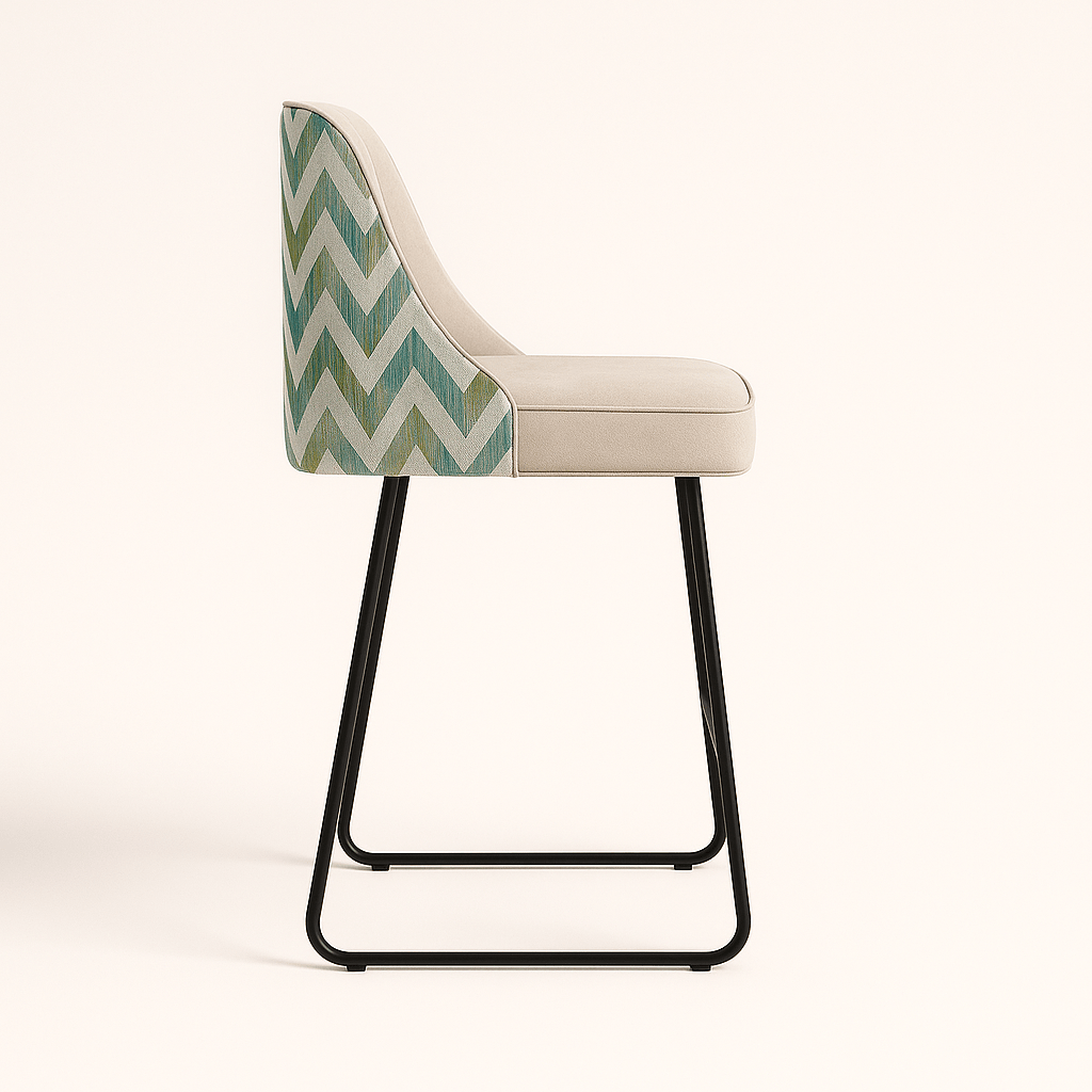 Modern bar and kitchen counter stool with a cream upholstered seat and vertical channel tufting, featuring a chevron-patterned fabric on the back and a sleek black metal sled base, set against a neutral background.