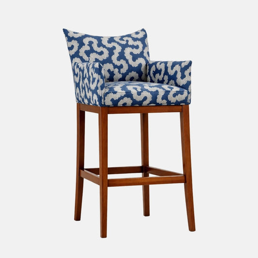 Blue-and-cream patterned upholstered bar stool with a low wraparound back and arms, padded seat, and dark wooden legs with lower stretcher rails.