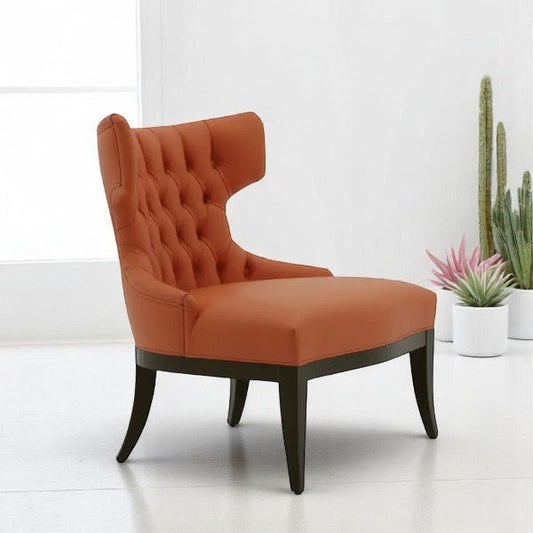 alt="Stylish orange velvet lounge chair with winged back and deep button cushions, set on black legs"