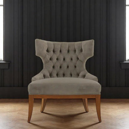 alt="Luxurious deep buttoned lounge chair with wingback design in orange velvet and contrasting black legs"