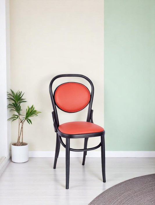 "Orange upholstered dining chair with oval backrest and black metal frame"