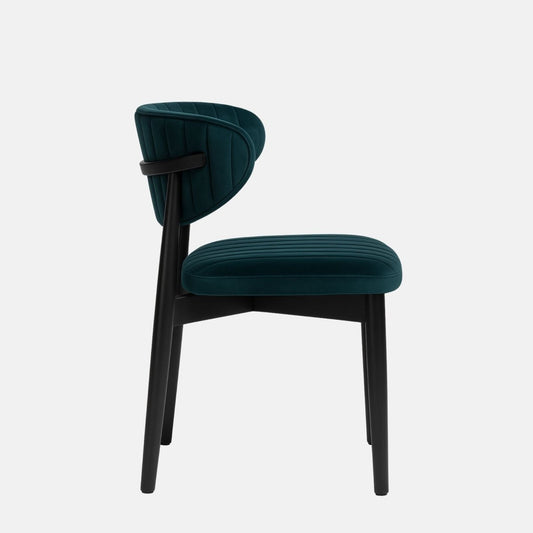 Modern dining chair with a black wooden frame and legs, featuring deep teal velvet upholstery on the curved backrest and seat with vertical channel stitching, set against a light grey background