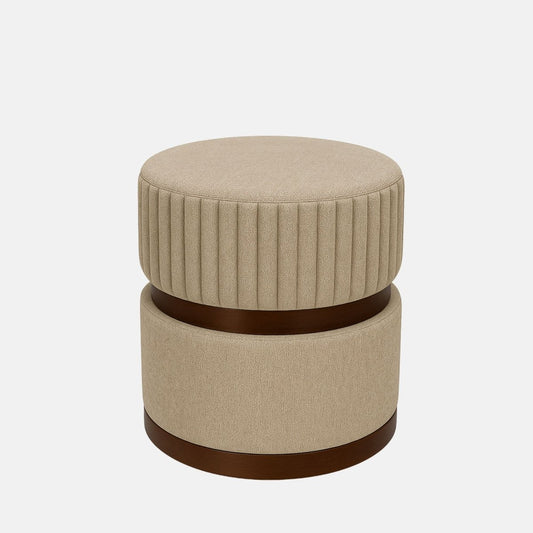 Beige upholstered round ottoman with ribbed detailing and dark wood band  modern fabric footstool or accent stool for living room, bedroom, or hotel lounge.