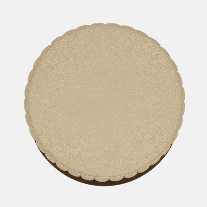 Beige upholstered round ottoman with ribbed detailing and dark wood band modern fabric footstool or accent stool for living room, bedroom, or hotel lounge.