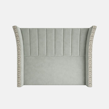 Upholstered headboard in soft green fabric with vertical fluted panels and winged sides featuring patterned trim, shown on a plain background.
