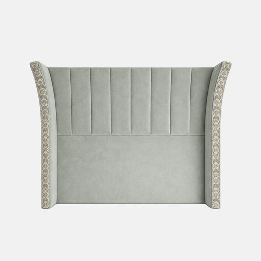 Upholstered headboard in soft green fabric with vertical fluted panels and winged sides featuring patterned trim, shown on a plain background.