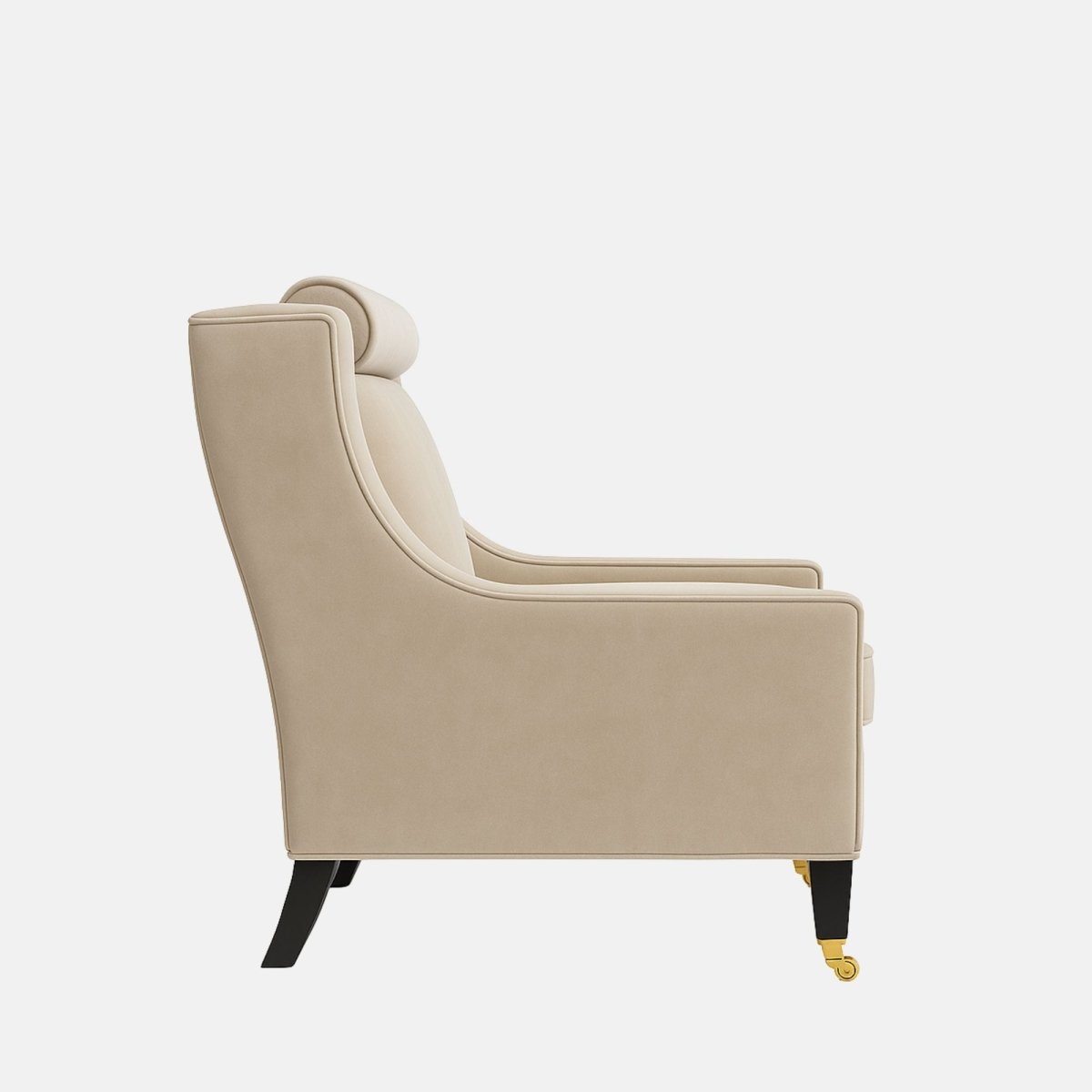 Beige upholstered armchair with curved sides, a cylindrical headrest, a cushioned seat, black legs, and brass front castors.