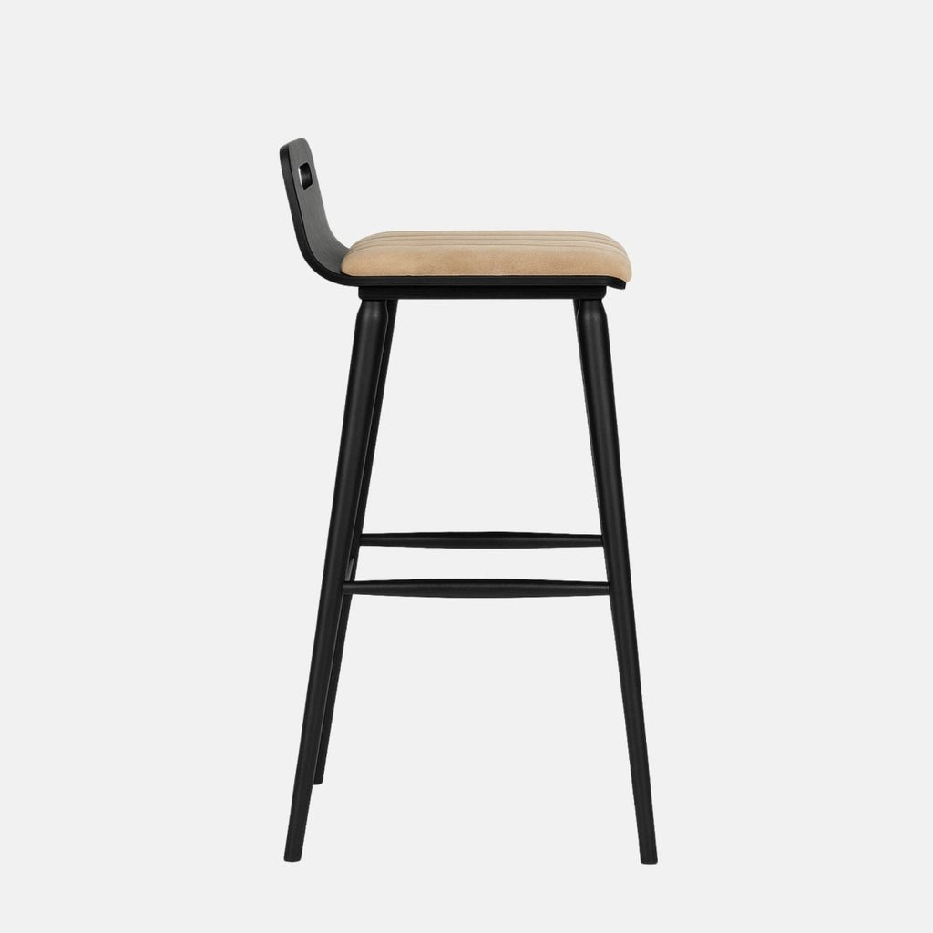 Modern bar stool with a black wooden frame, low backrest featuring an oval cutout, beige upholstered seat, and metal footrest.