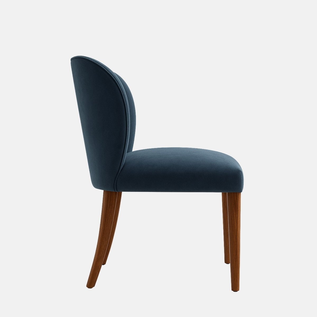 Upholstered dining chair in deep navy-blue fabric with a curved wraparound backrest, cushioned seat, and dark wooden legs, shown on a white background