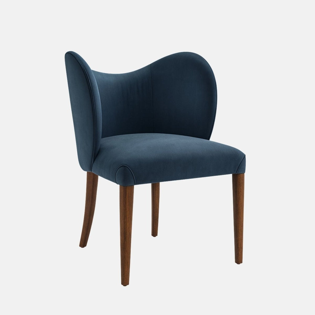 Upholstered dining chair in deep navy-blue fabric with a curved wraparound backrest, cushioned seat, and dark wooden legs, shown on a white background