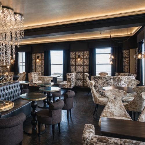 Luxury restaurant interior with elegant dining tables, upholstered chairs and chandelier lighting