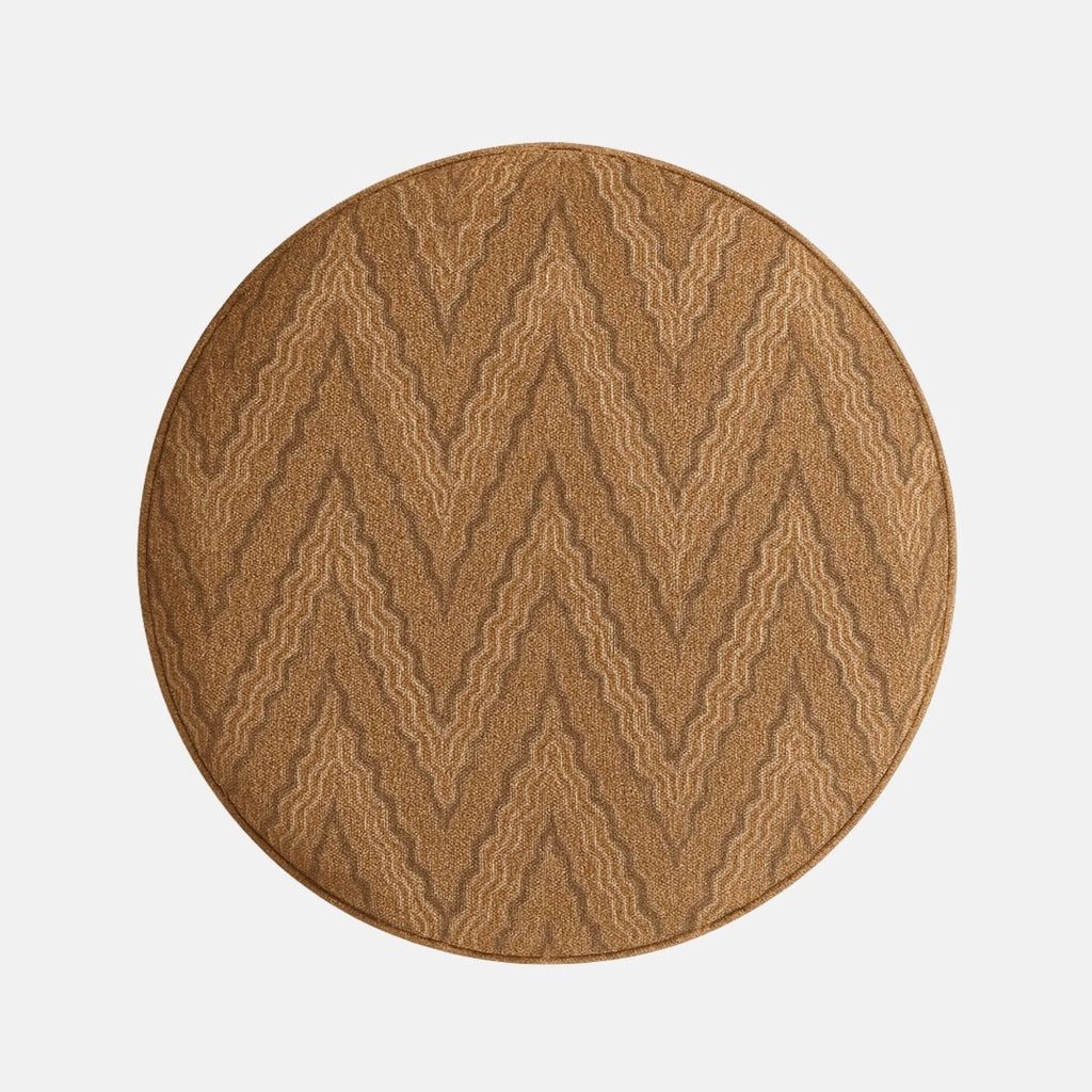 Round upholstered ottoman stool with brown zigzag patterned fabric and four short black wooden legs