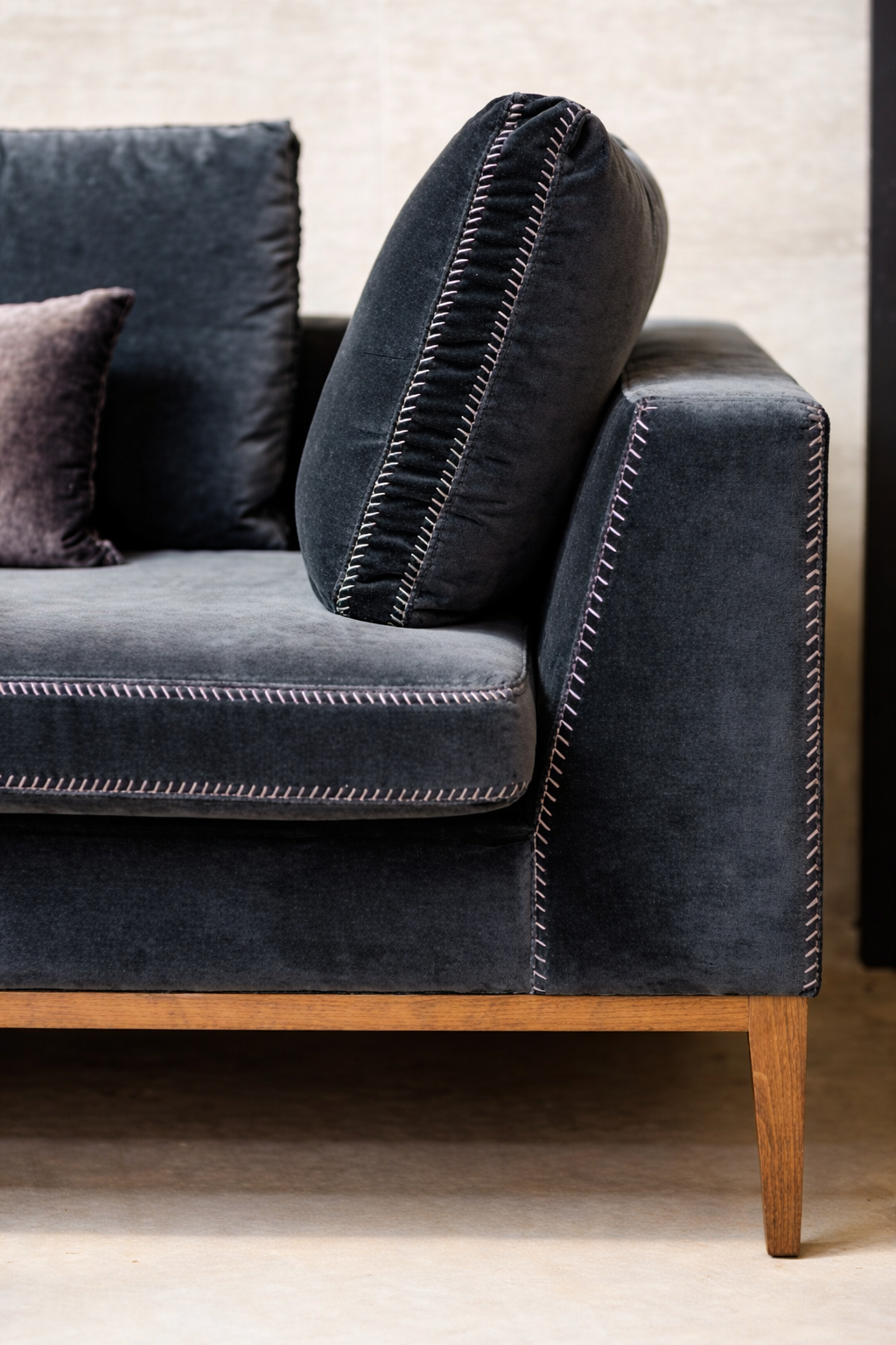 Luxury upholstered sofa with contrast stitching and wooden legs