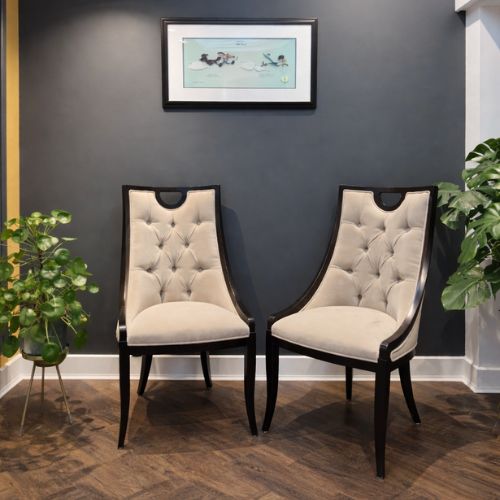 Elegant upholstered accent chairs in modern luxury interior with dark wall decor