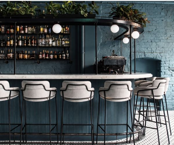 Modern bar interior with upholstered bar stools and marble counter