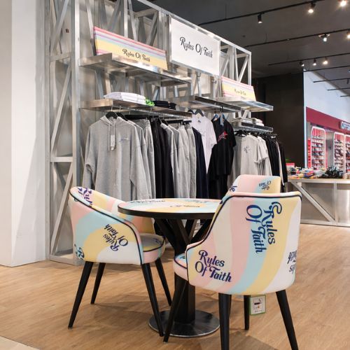 Modern fashion retail store interior with clothing display racks and boutique seating area