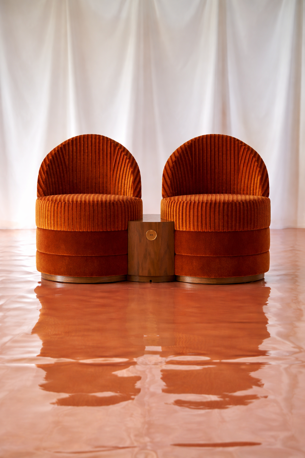 Pair of modern orange velvet accent chairs with ribbed upholstery and wooden side table