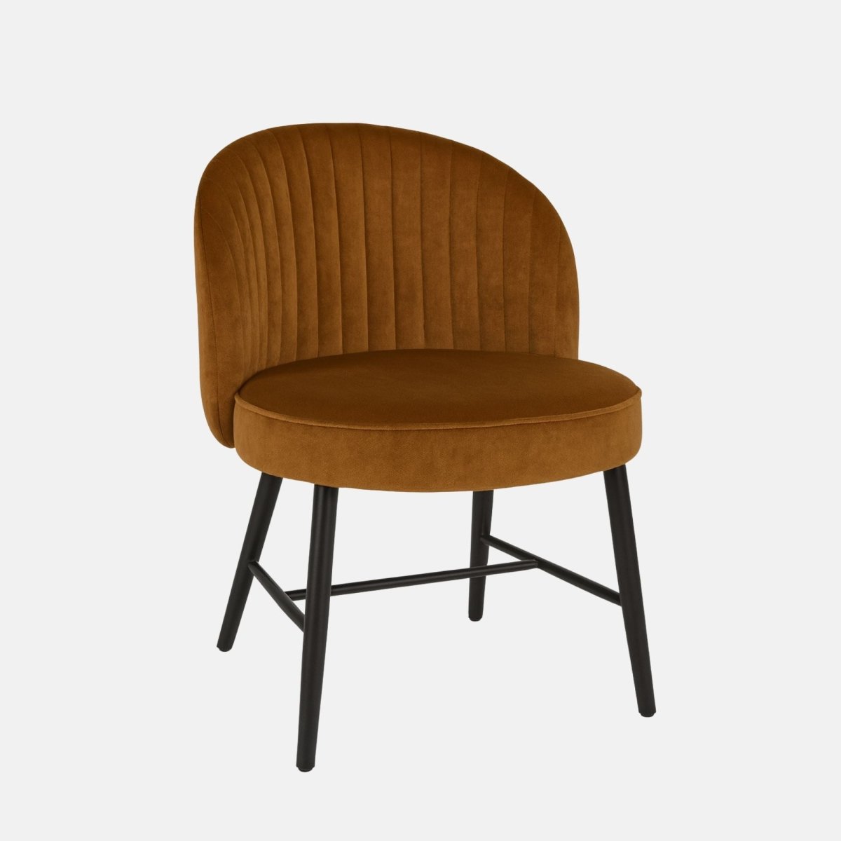 Modern dining chair with black metal legs and a rounded backrest, upholstered in warm caramel velvet with vertical channel stitching, set against a light grey background