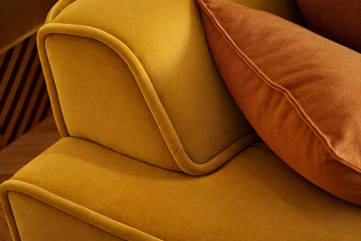 Close-up of mustard velvet sofa with soft upholstery and matching cushion.