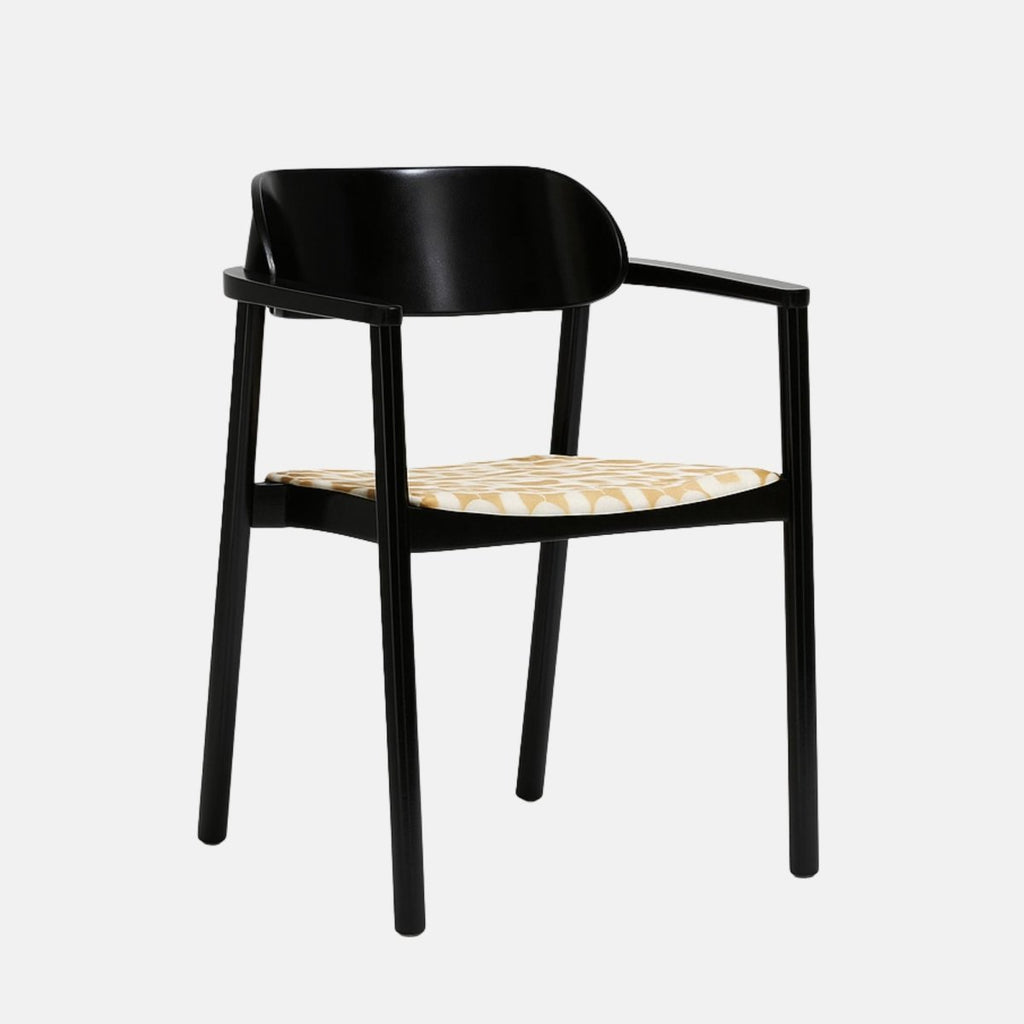 Contemporary armchair with a sleek black wooden frame and gently curved backrest, featuring a patterned beige and white upholstered seat, set against a light grey background