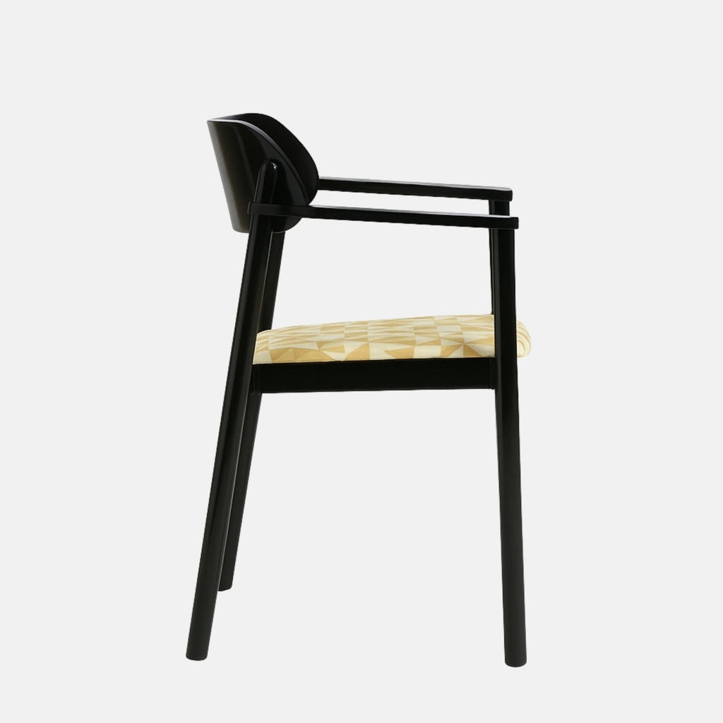 Contemporary armchair with a sleek black wooden frame and gently curved backrest, featuring a patterned beige and white upholstered seat, set against a light grey background