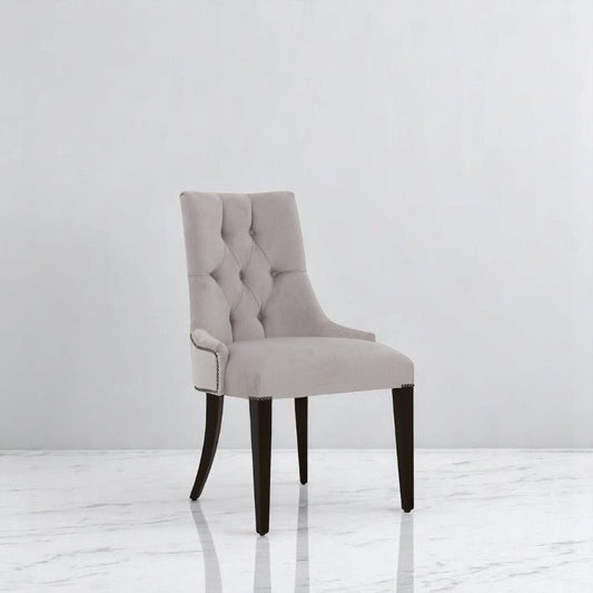 alt="Modern dining chair with buttoned back design in natural color and sleek black legs"