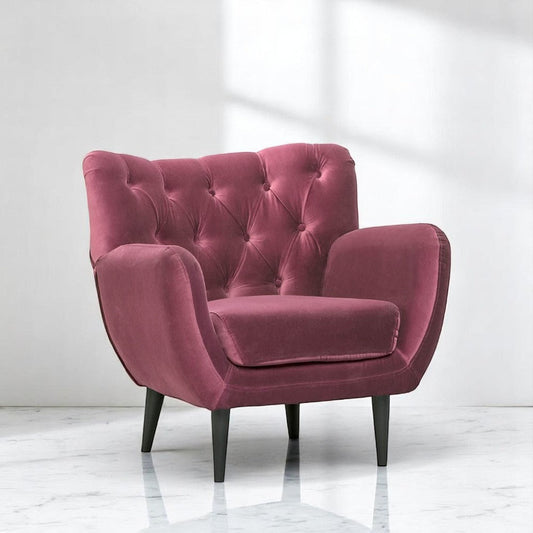 alt="Chic pink lounge chair featuring deep button cushions and contrasting black legs"