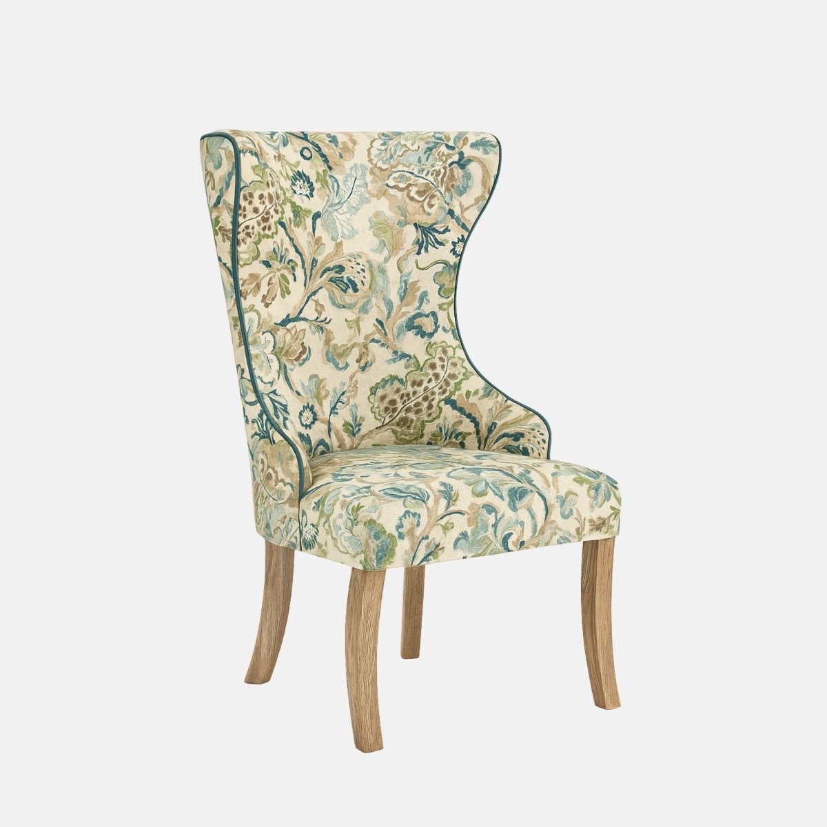 Upholstered dining chair with a high, winged backrest and cushioned seat, covered in a floral-patterned fabric in soft green, blue, and beige tones, finished with contrast piping and natural wooden legs, shown on a white background