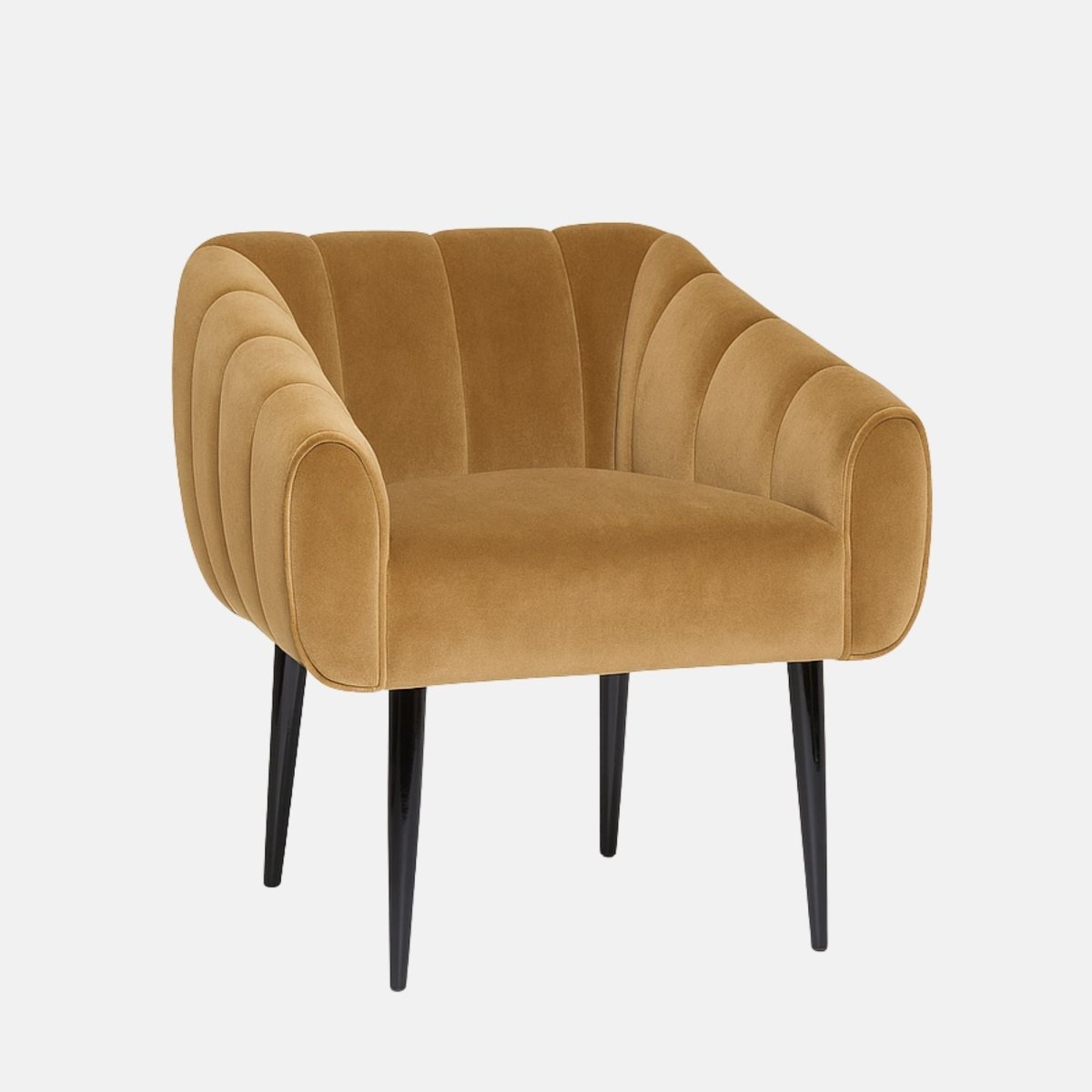 Camel velvet lounge chair with rounded, channel-tufted sides and backrest, paired with slim black tapered legs