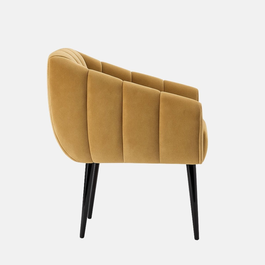 Camel velvet lounge chair with rounded, channel-tufted sides and backrest, paired with slim black tapered legs