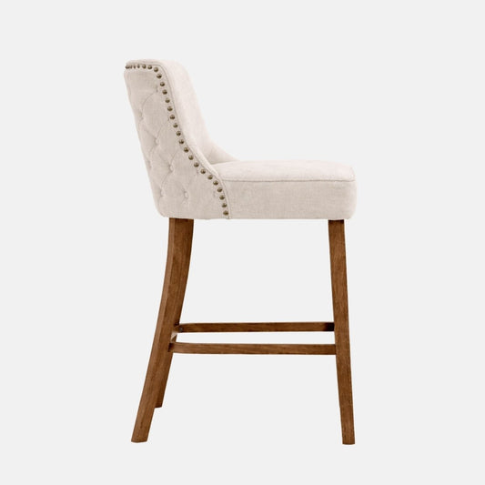 Cream upholstered regency bar stool with button tufted back, studded detailing and wooden legs